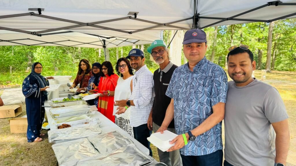Volunteers serving lunch from the buffet line under the catering tent.