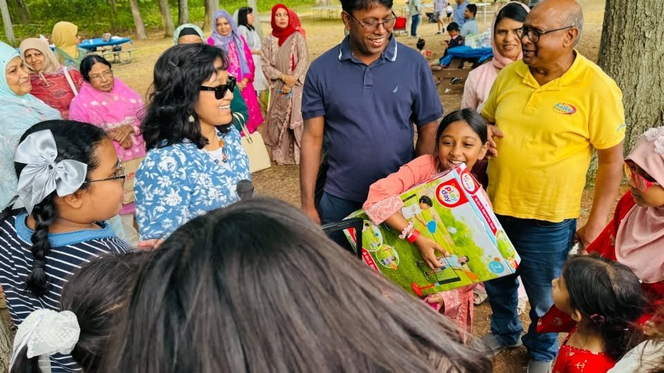 Families queuing at the prize table, one child holding a wrapped gift.