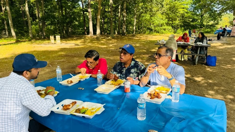 Guests eating lunch together at a picnic table.
